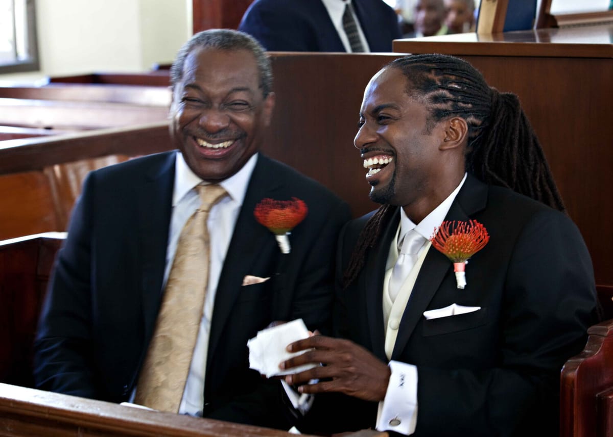 Groom laughing with a loved one during the church wedding ceremony
