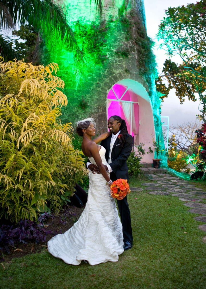 Newlyweds embracing in a colorful tropical garden after their wedding