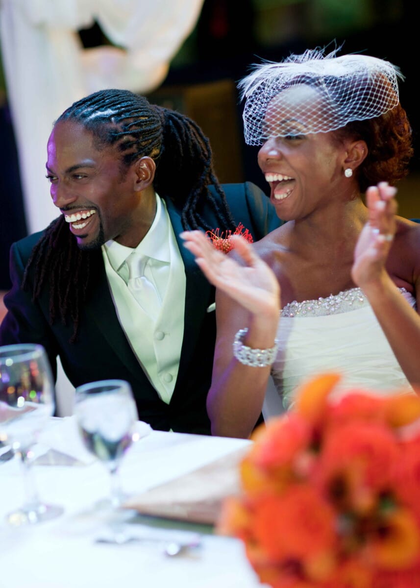 Newlyweds laughing together during their wedding reception