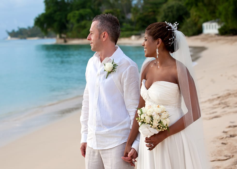 Newlyweds holding hands during a quiet portrait on a Barbados beach