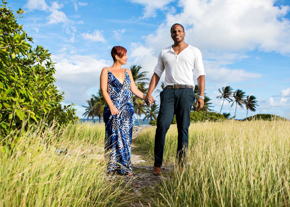 Couple holding hands on a coastal path in Barbados