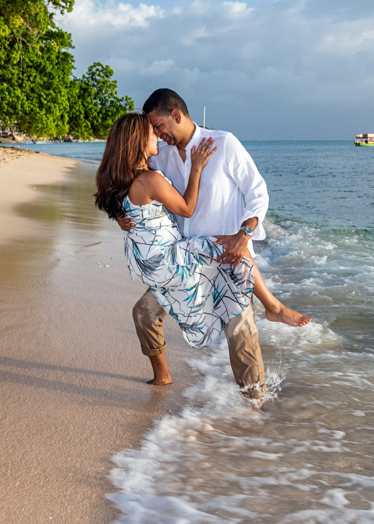 Couple embracing in the surf during a Barbados beach portrait session