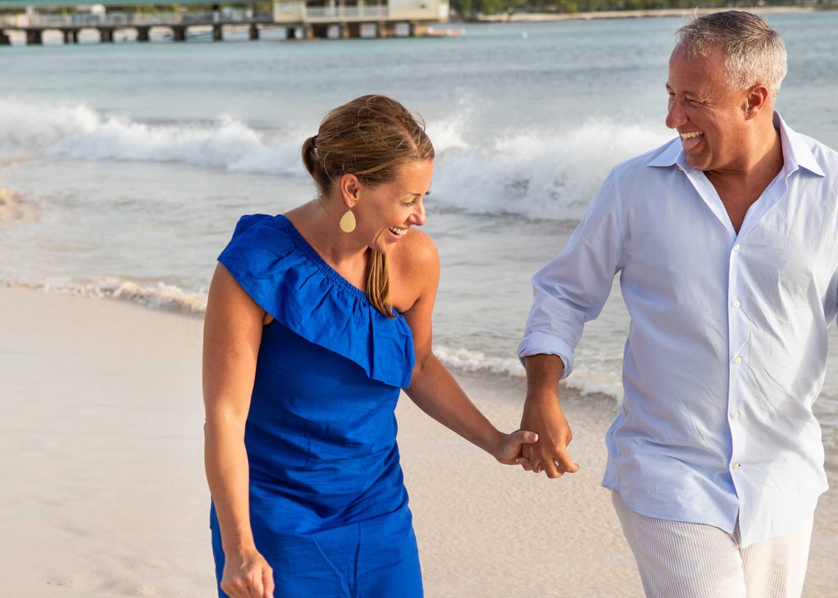 Couple walking hand in hand along a Barbados beach
