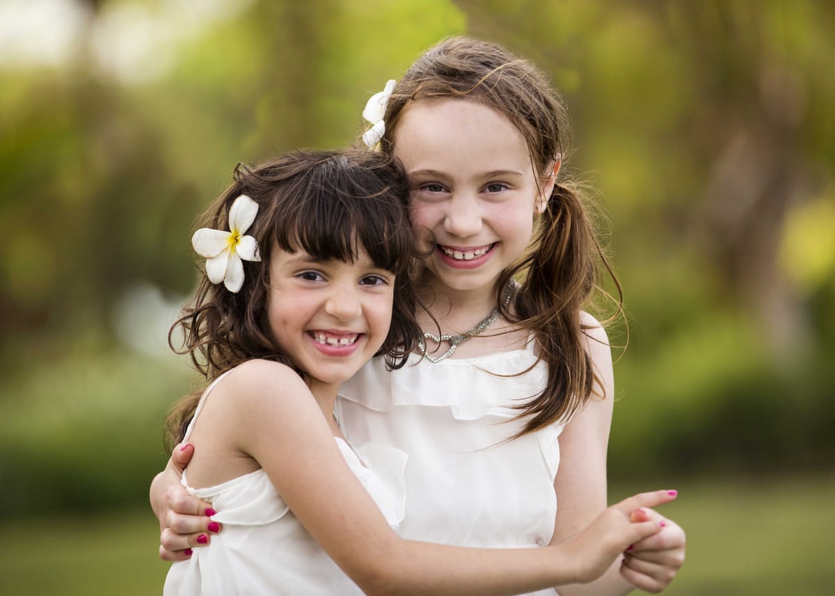 Two girls hugging during an outdoor family portrait session
