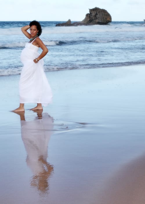 Expectant mother posing on the shoreline during a Barbados maternity session