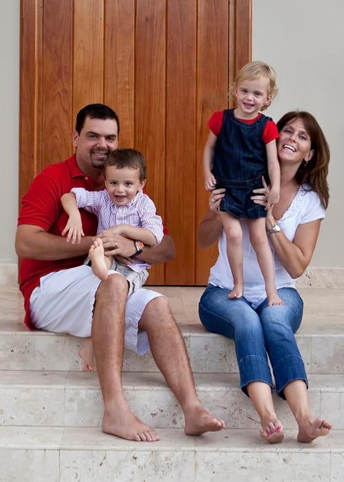 Family of four laughing together on outdoor steps