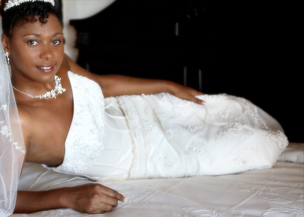 Bride reclining in her wedding gown and veil before the ceremony
