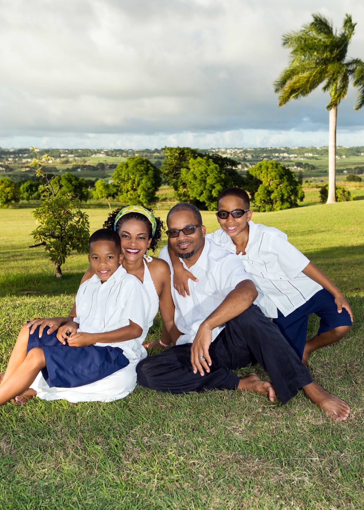 Family of four seated together in the Barbados countryside