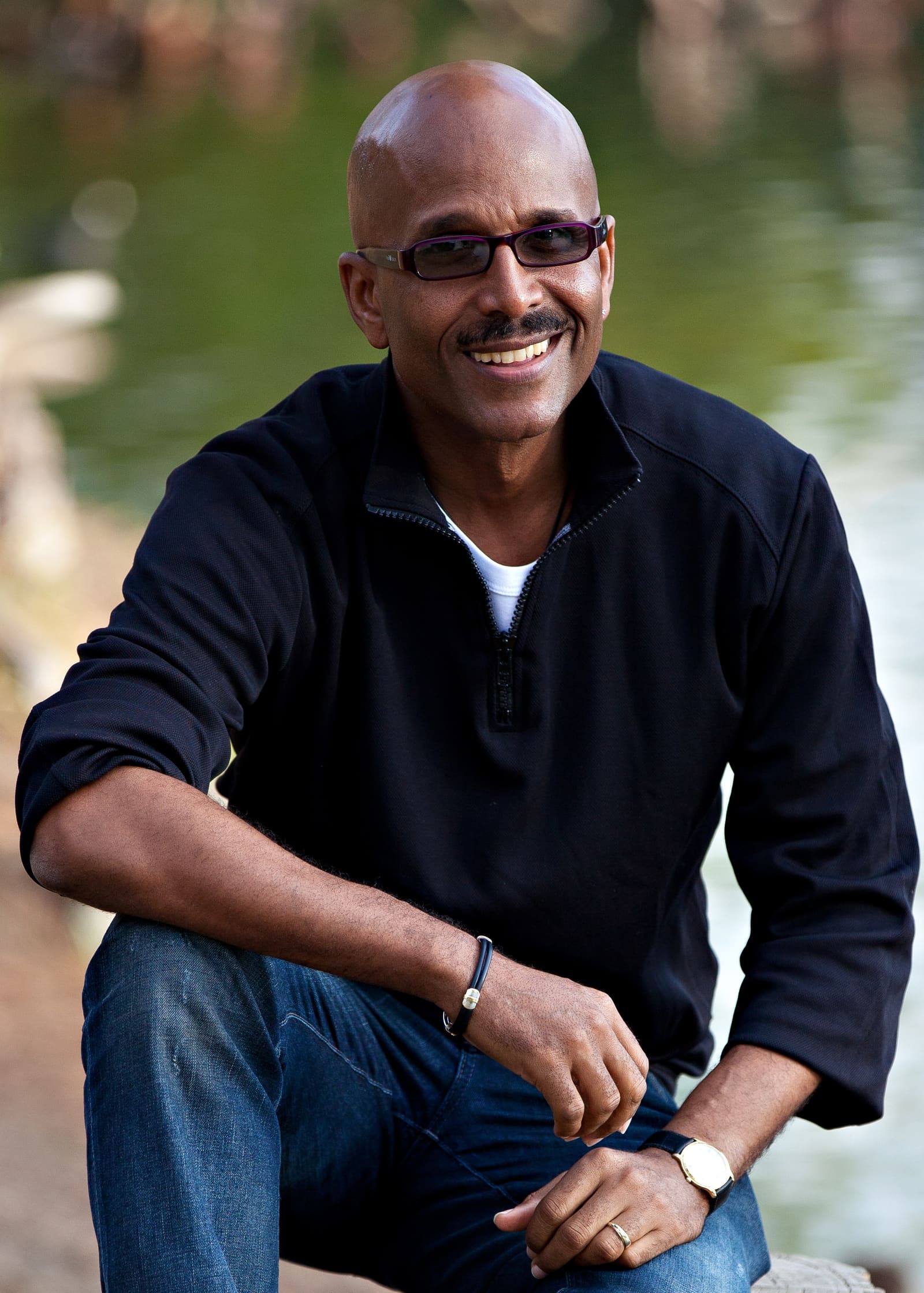 Steven Cumberbatch, Barbados wedding and family photographer, smiling beside the water