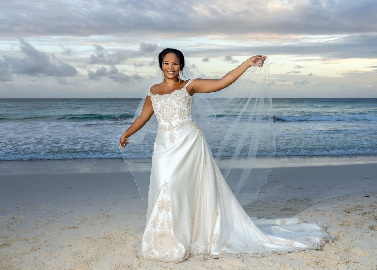 Bride spreading her veil on the beach, Barbados