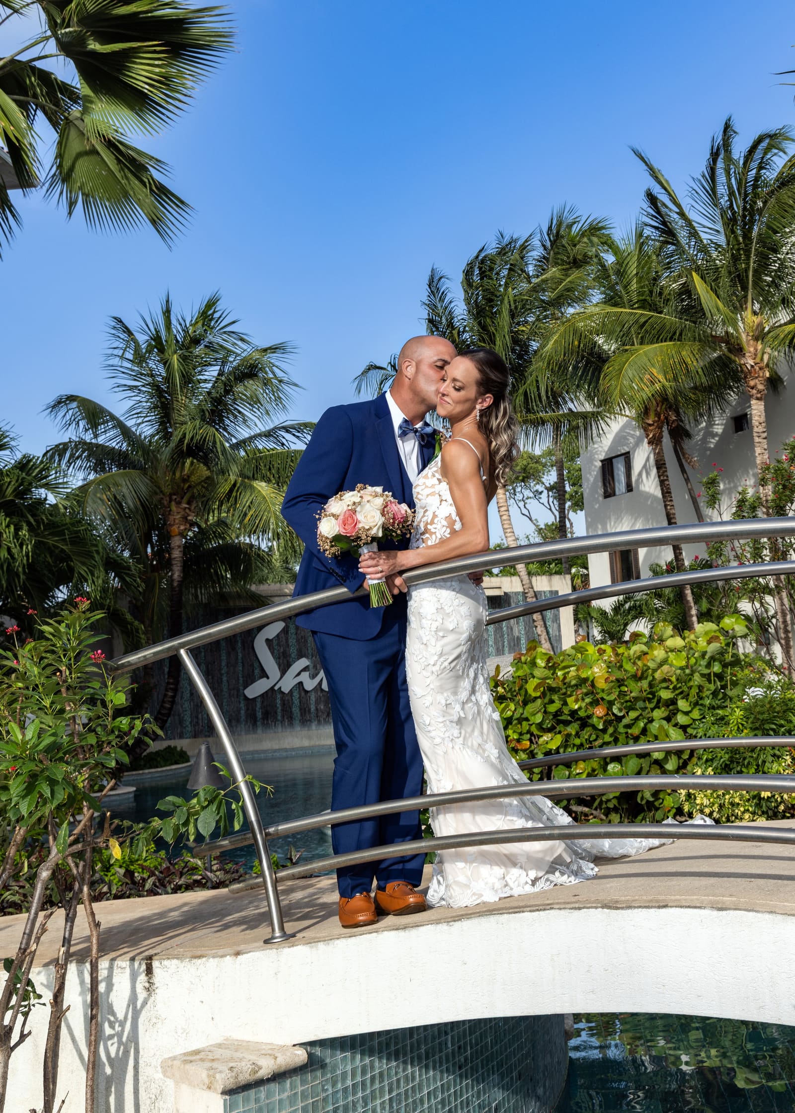 Couple embracing on a footbridge under palm trees, Barbados
