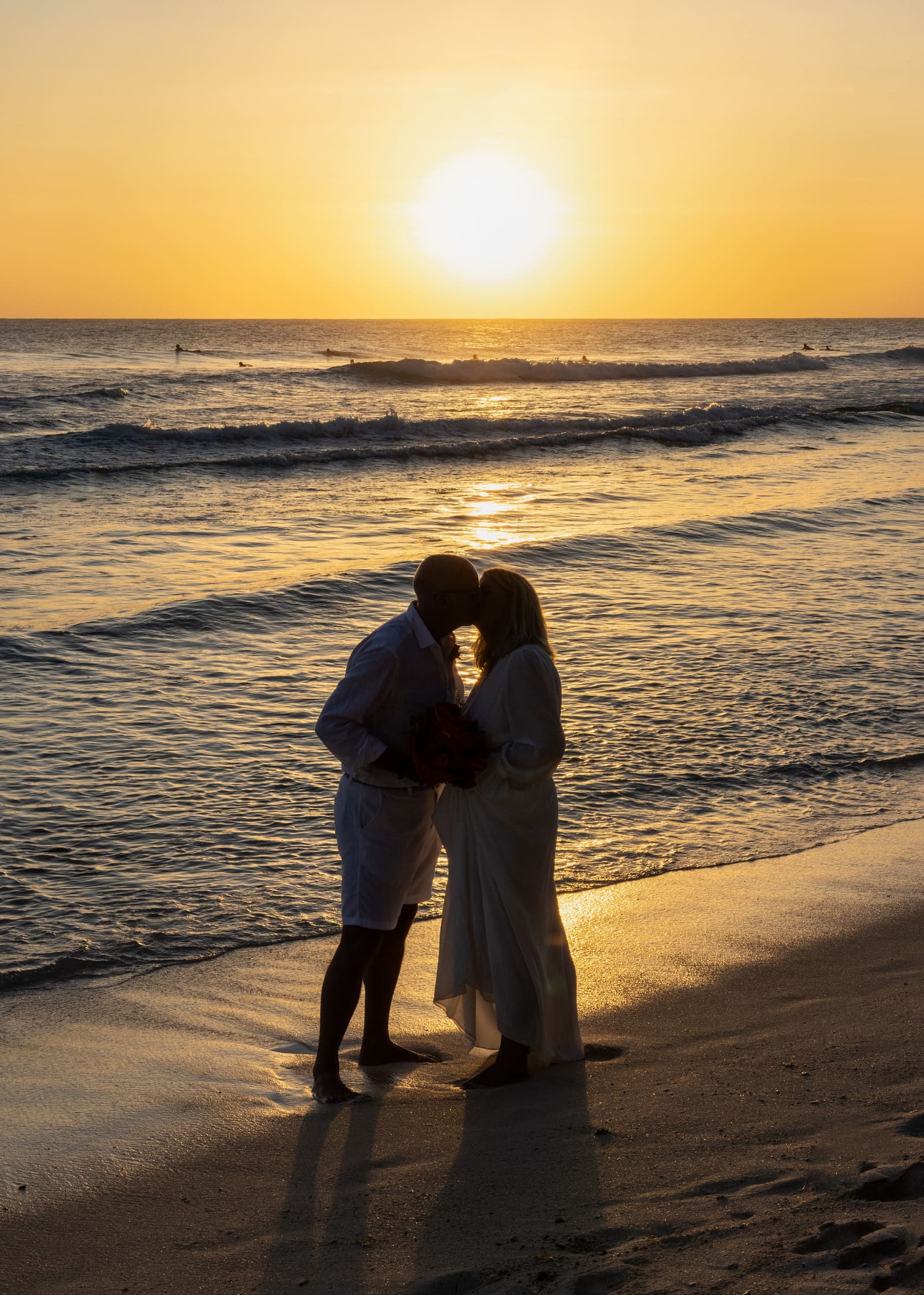 Couple kissing in silhouette at sunset, Barbados