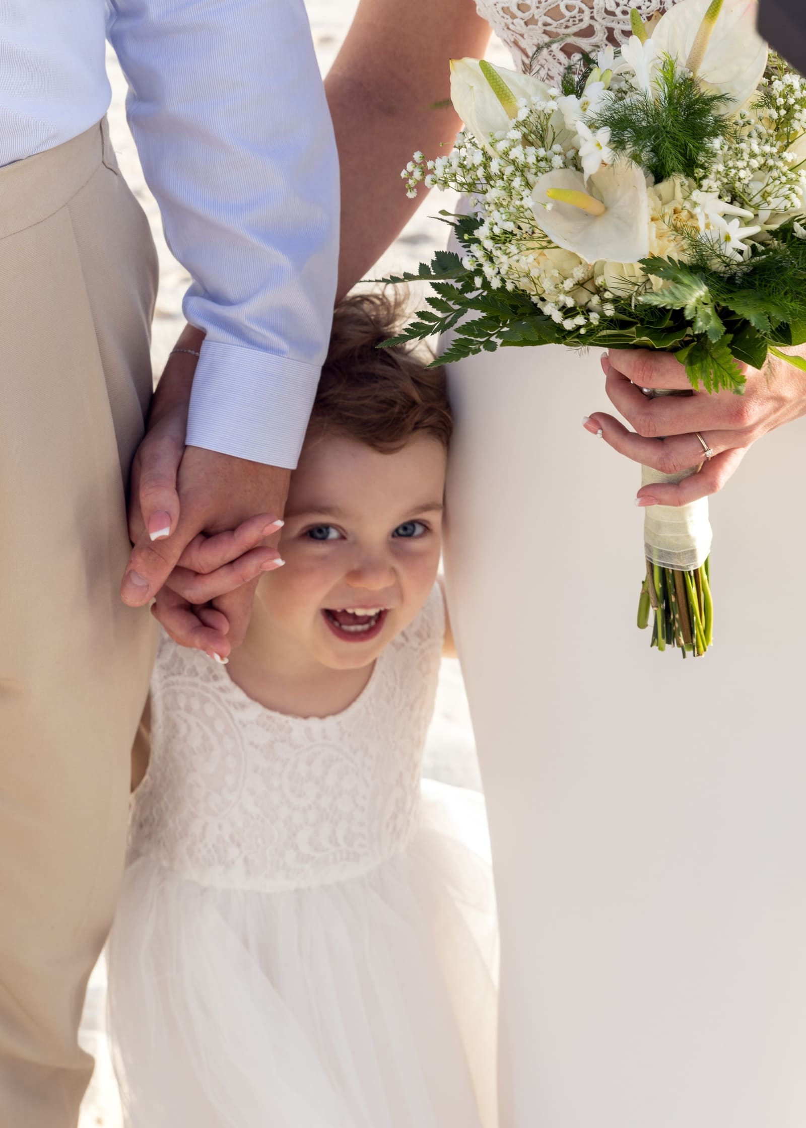 Flower girl peeking out from behind the bride, Barbados