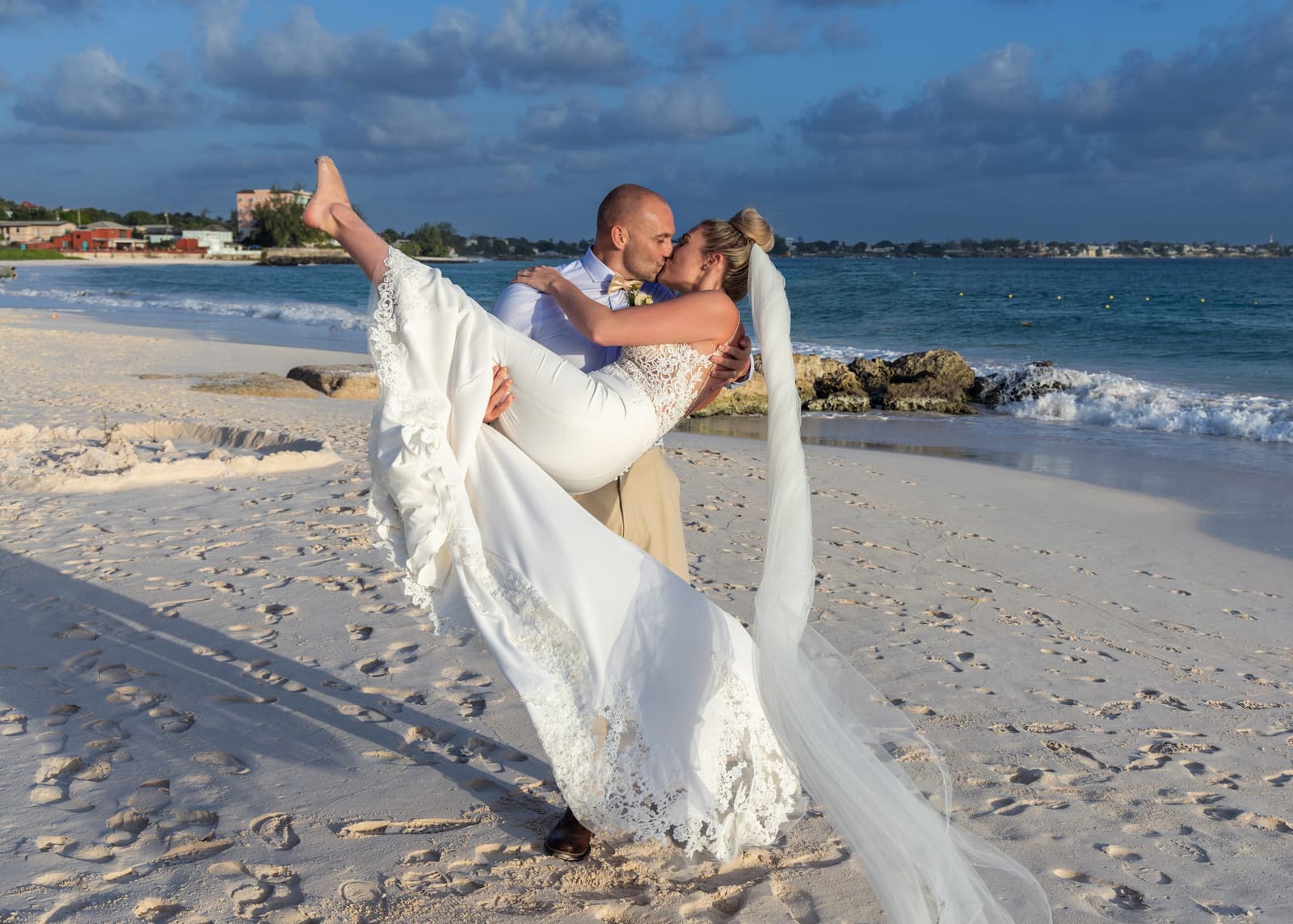 Groom lifting the bride on the beach, Barbados
