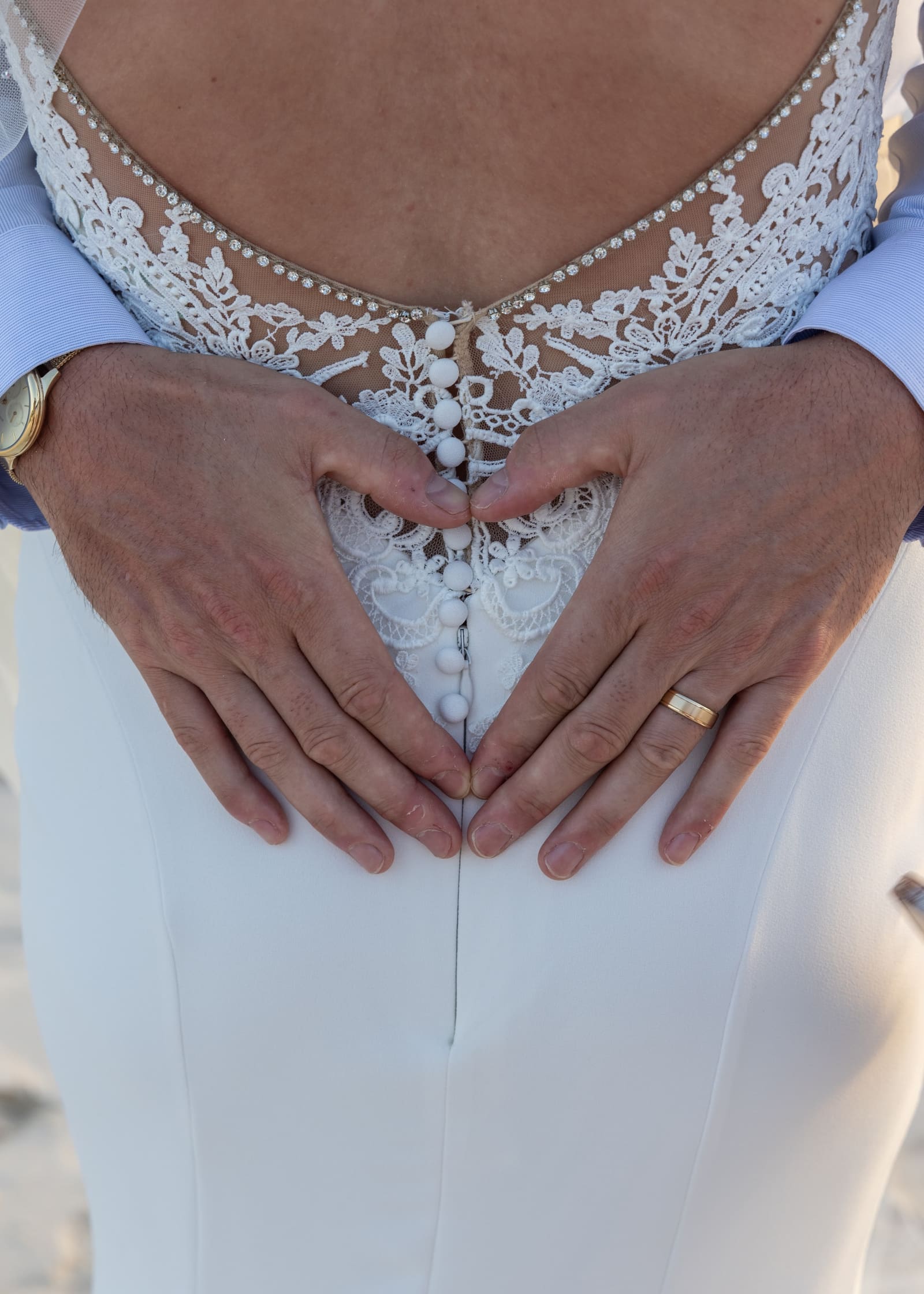 Close-up of the bride’s lace dress as the couple join hands, Barbados