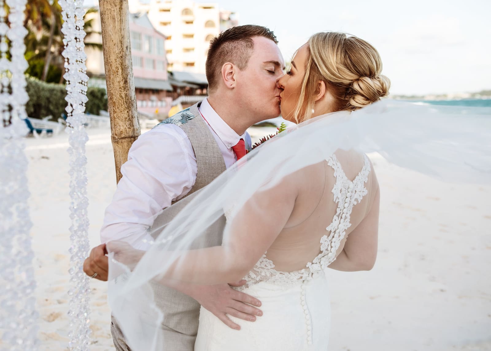 Couple kissing as the bride’s veil lifts in the breeze, Barbados