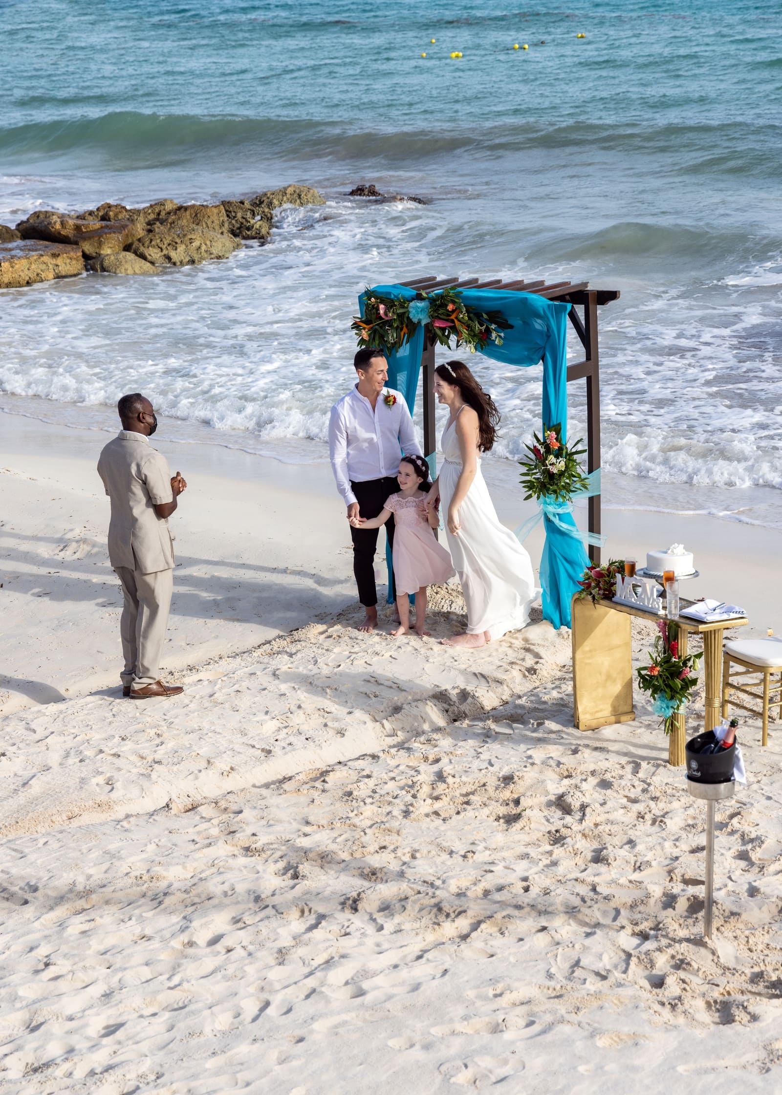 Beach ceremony under a blue-draped arch, Barbados