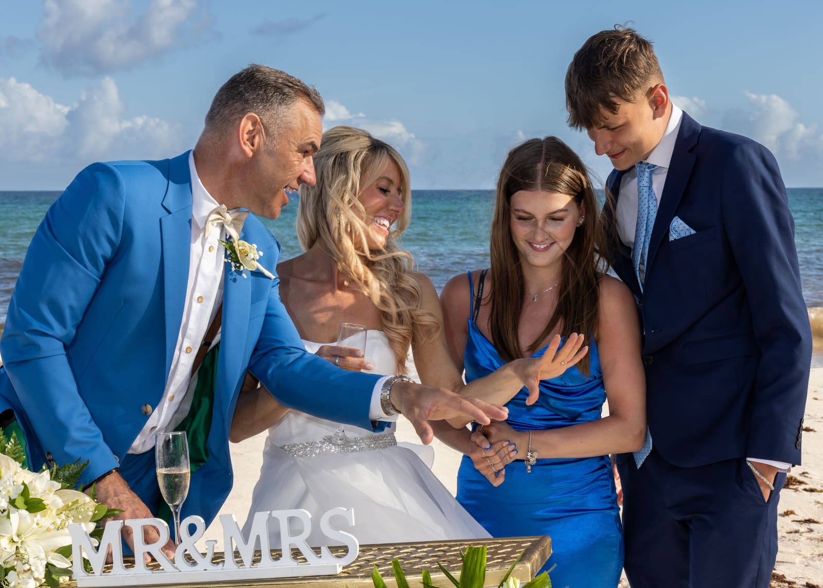 Couple and their children at the signing table on the beach, Barbados