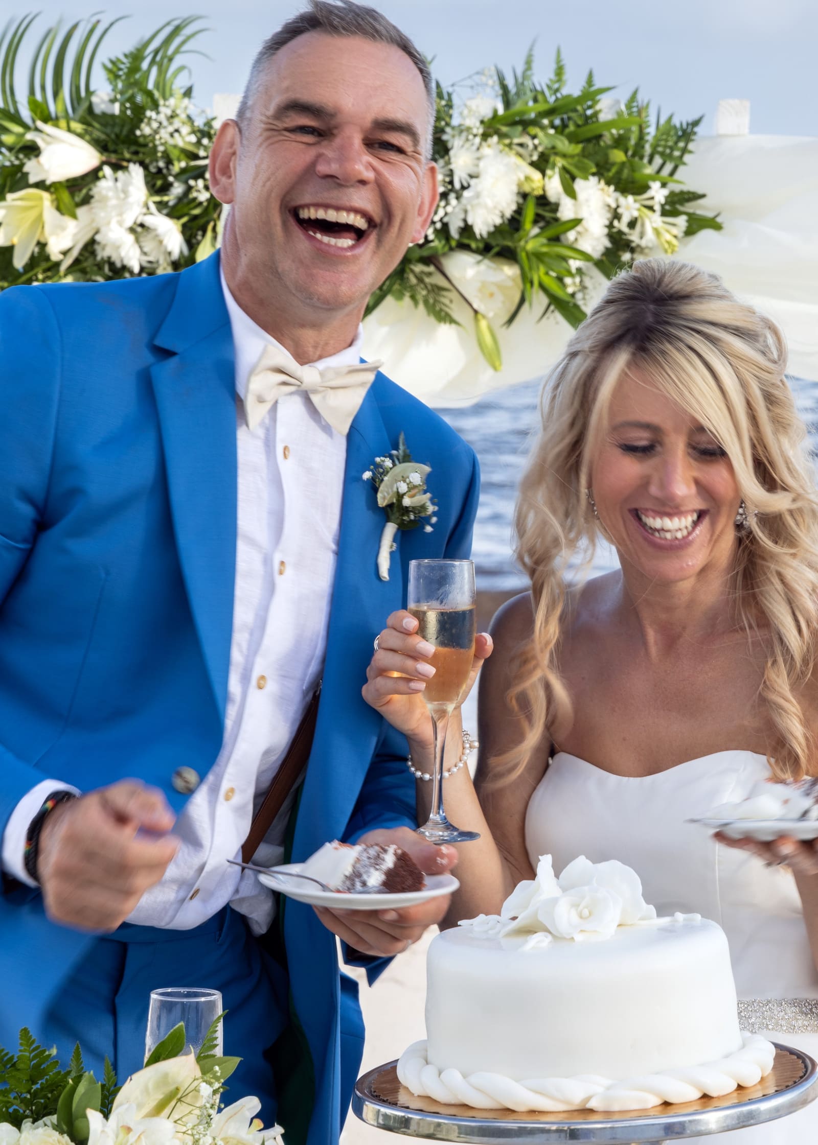 Couple laughing as they cut their wedding cake, Barbados