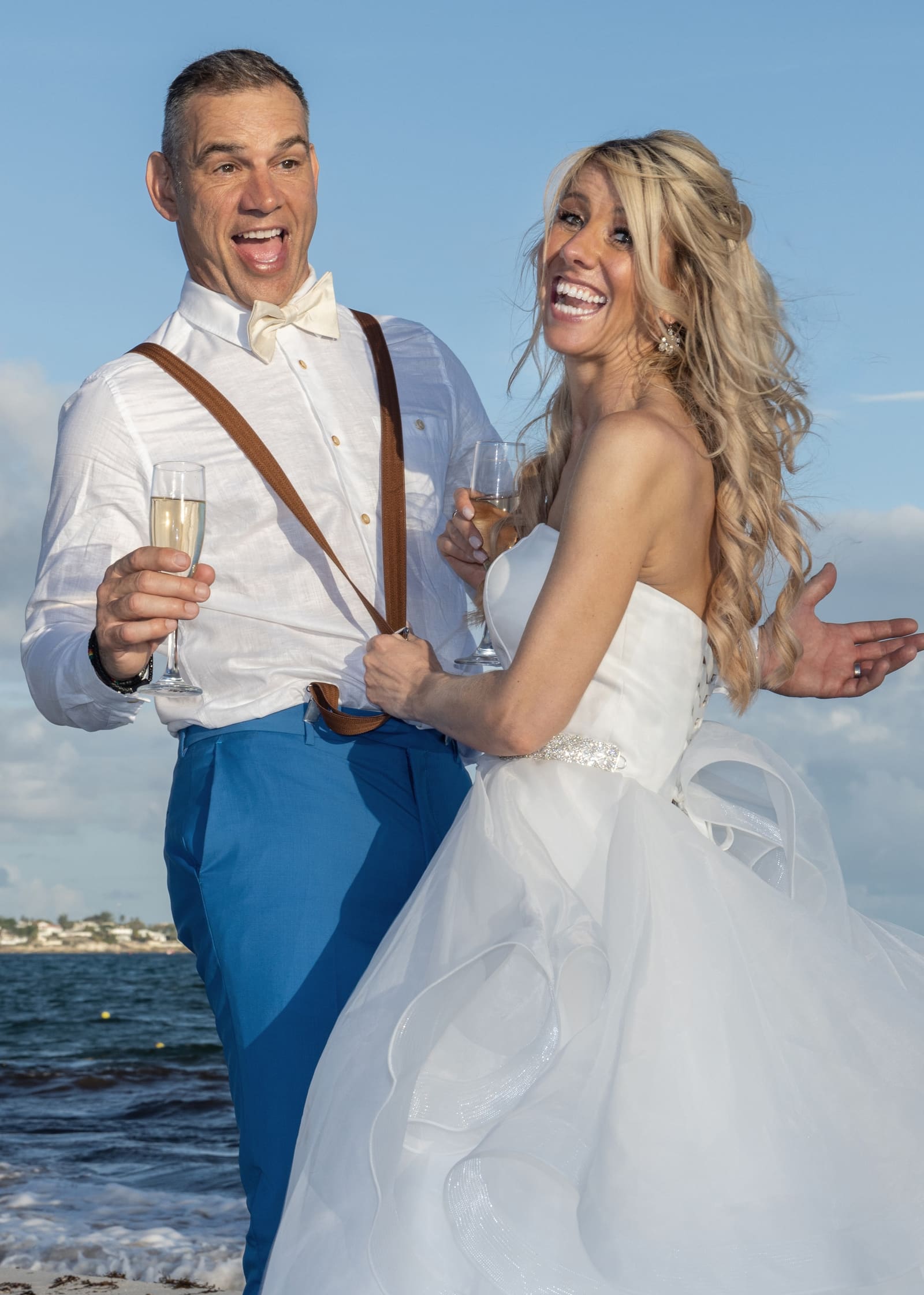 Groom raising a toast as the bride laughs, Barbados