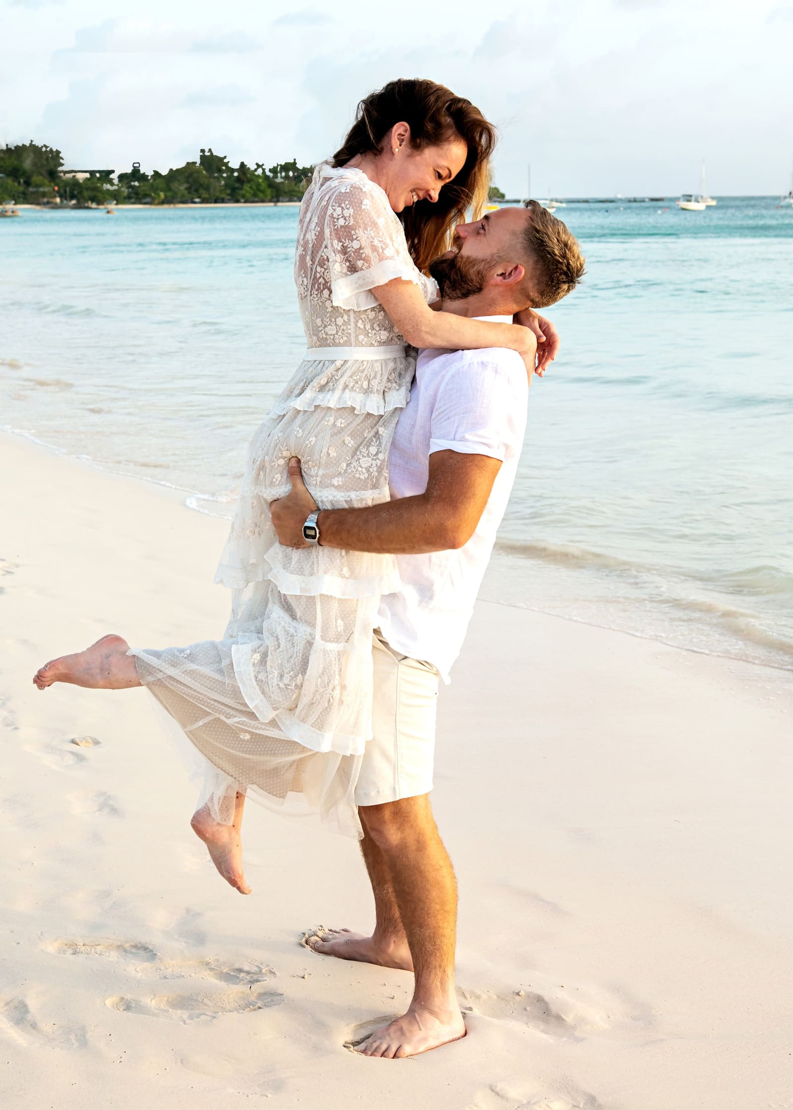Groom lifting the bride on the beach, Barbados